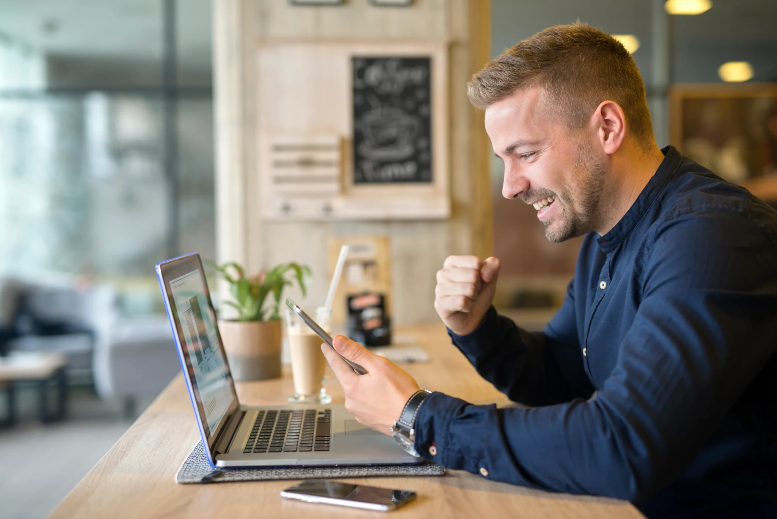 happy freelancer with tablet laptop computer coffee shop scaled Interwebsite Webbyrå